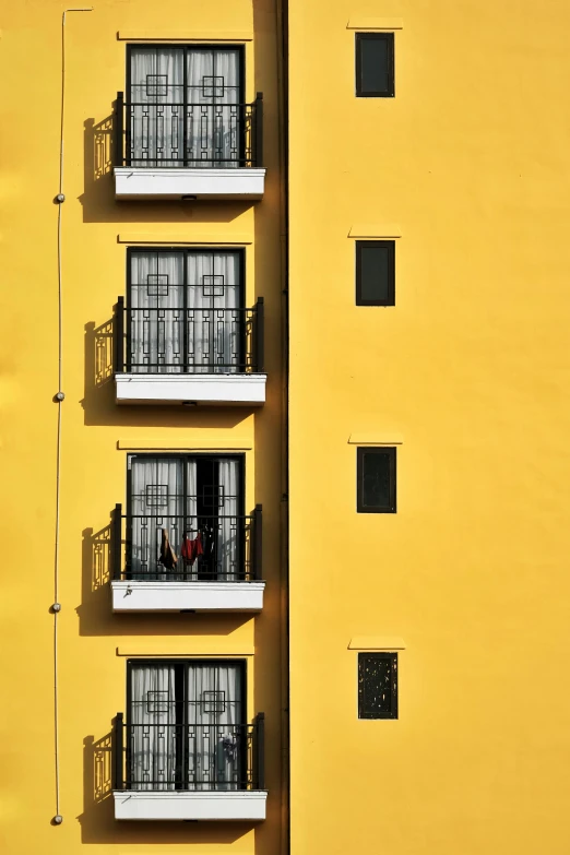 the building has a balcony on it with metal bars between the windows