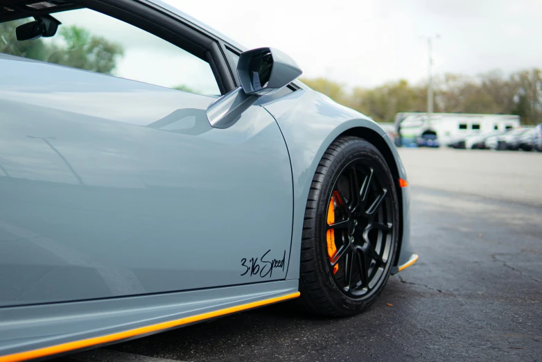 the front of a gray sports car parked in a lot