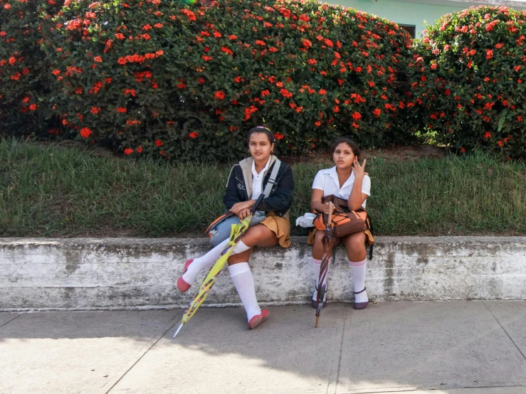 two people sitting on a wall with their back to the camera