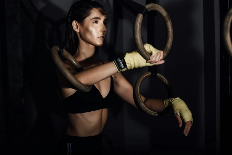 a woman holding onto two large rings with her hands