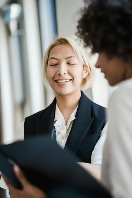 a woman sitting down having a conversation with another woman