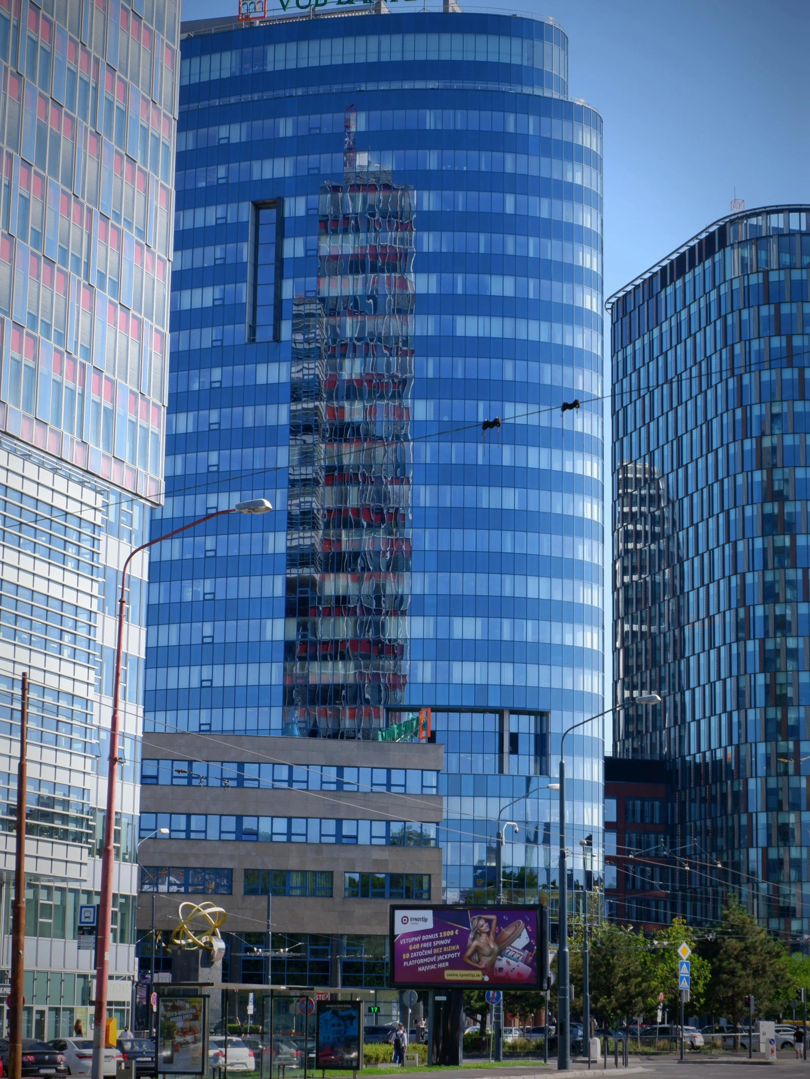 a very tall blue building sitting next to other buildings