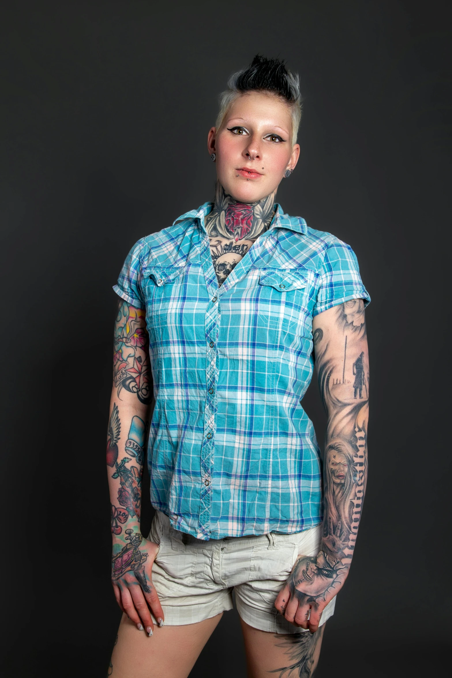 a beautiful tattooed woman posing with her hands on her hips