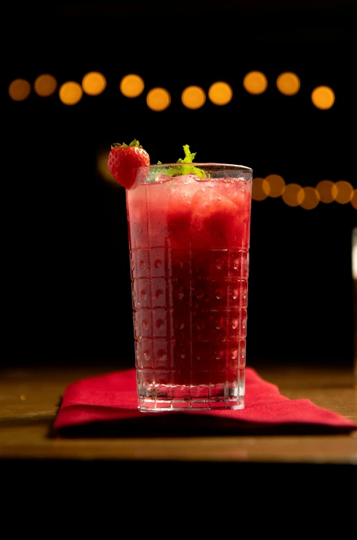 a drink is on a table with lights in the background