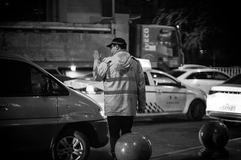 black and white image of a person on the street at night