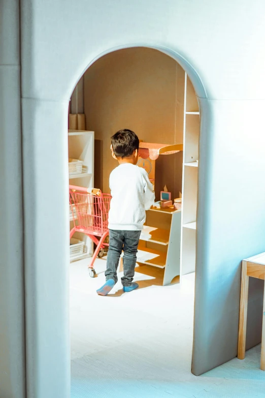 a little boy is standing in front of a blue wall