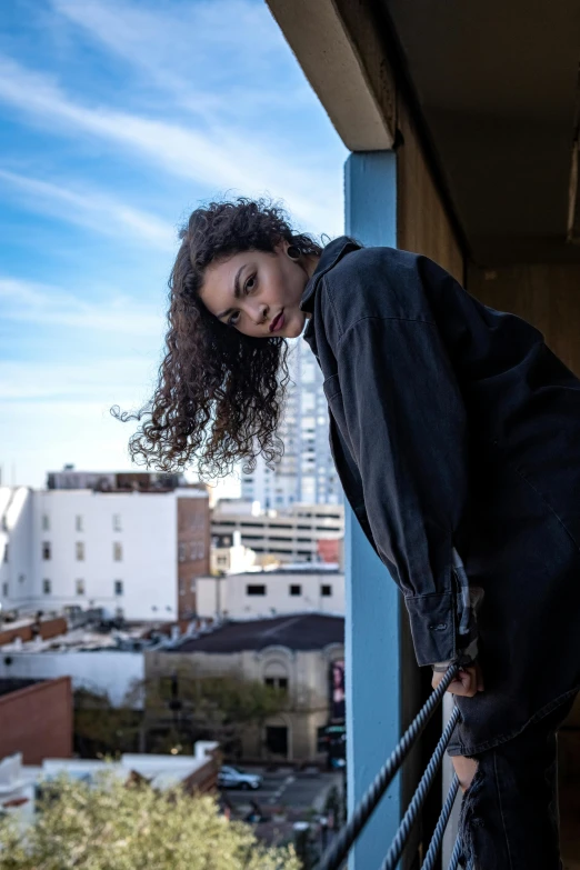 a woman leaning on a balcony ledge overlooking city