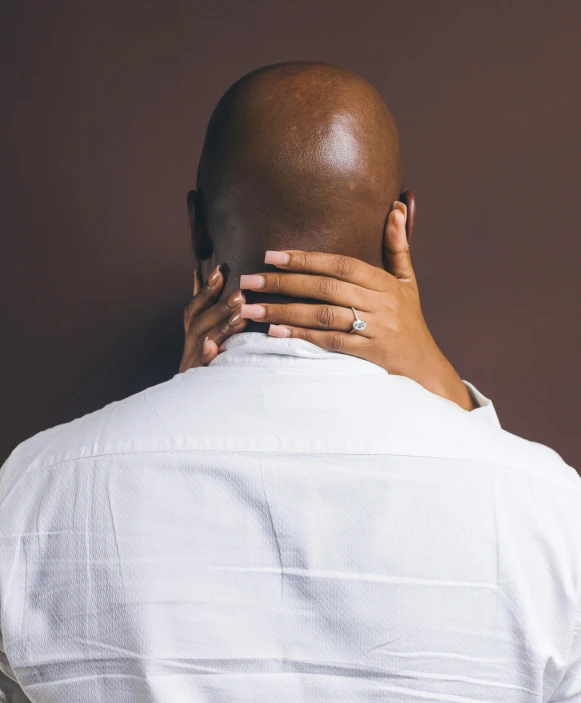 a man covers his face with a woman's hand