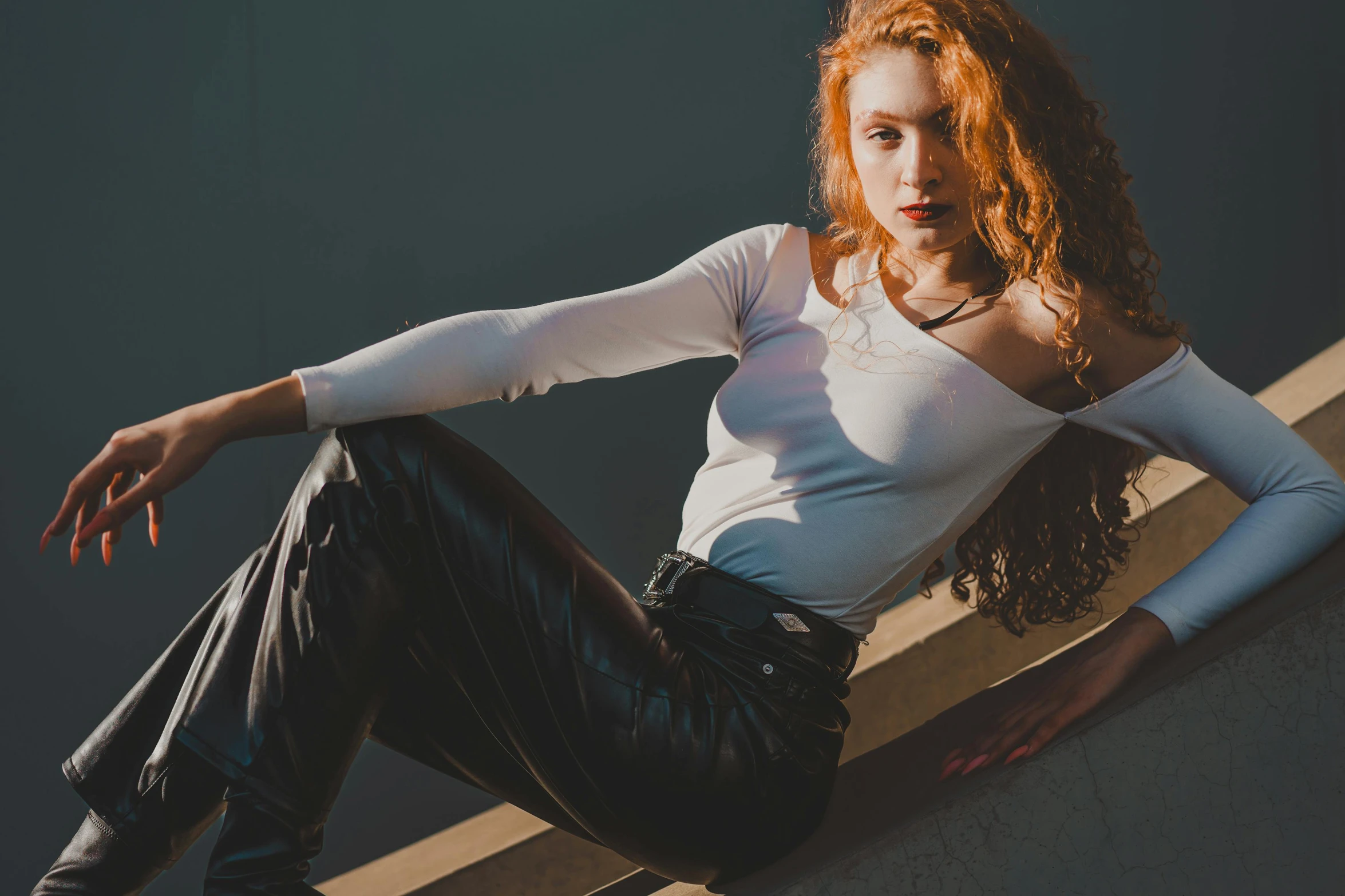 a woman sitting on a wall with her arms spread