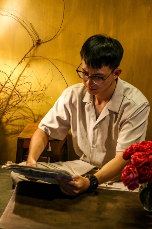 a man sitting at a table reading a book