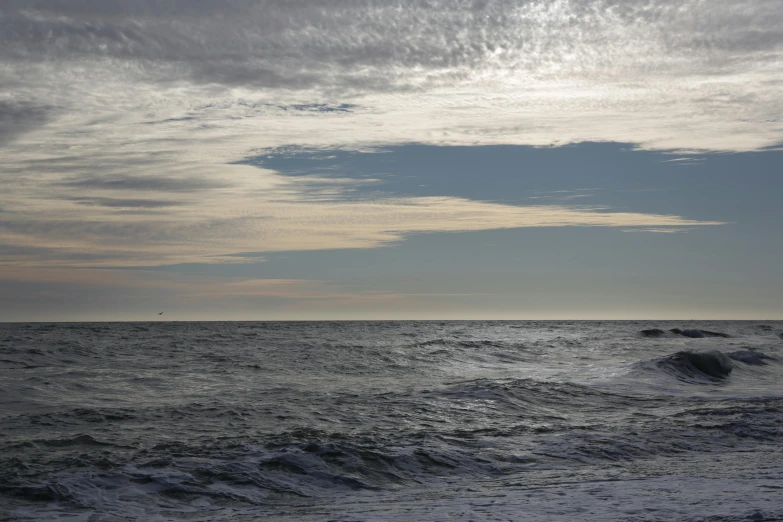 a black and white po of the ocean with clouds