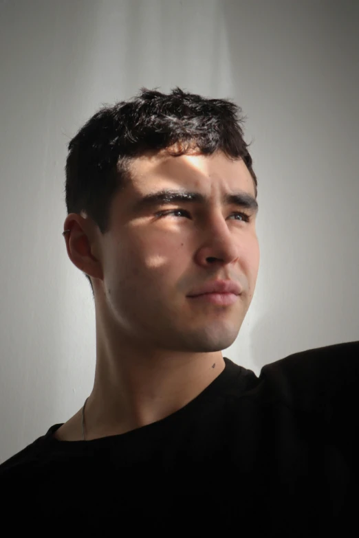 a man's face in shadow and against a white background