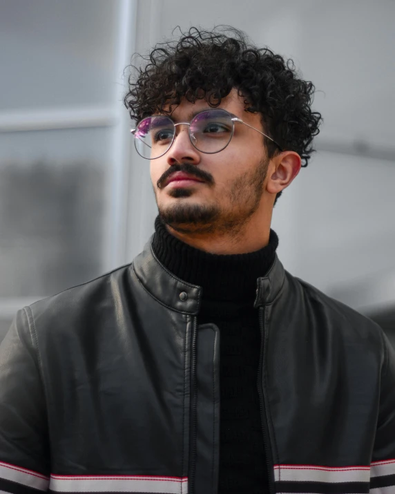 a man in black wearing glasses and a jacket