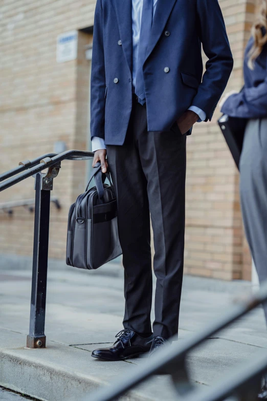 a man in a suit standing outside with a briefcase