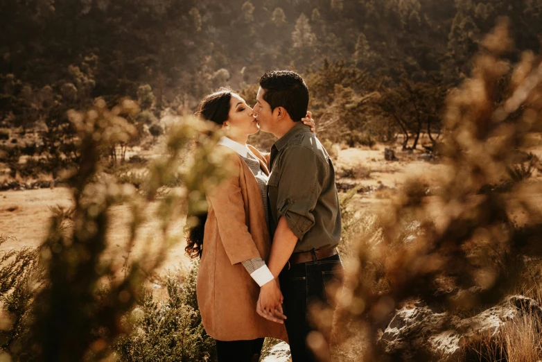 a man and a woman standing next to each other under trees