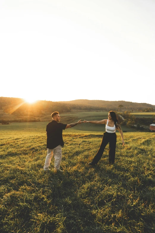 two people in a field playing with a kite