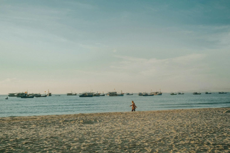 a beach with lots of boats out to sea