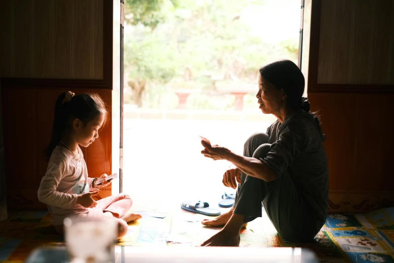 a woman and her child sitting down by a door