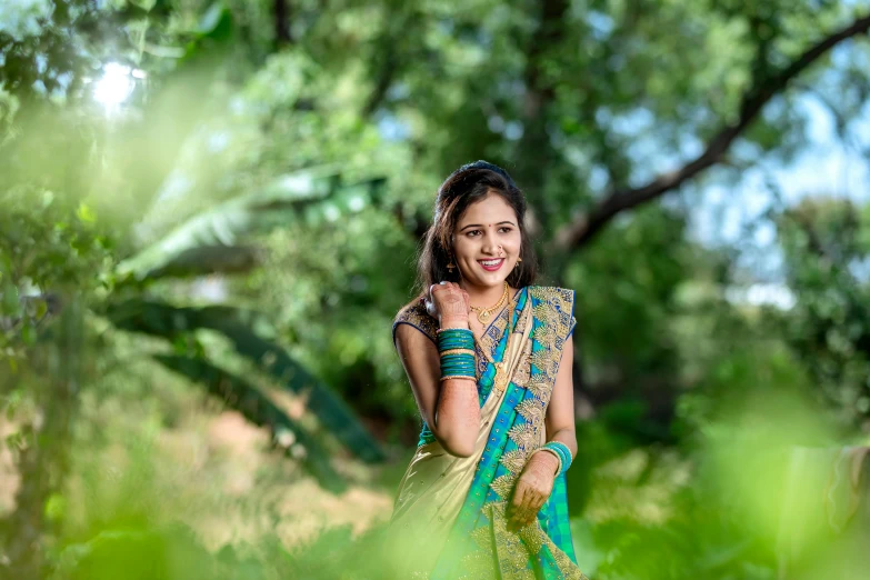 a smiling woman posing for a picture in a forest