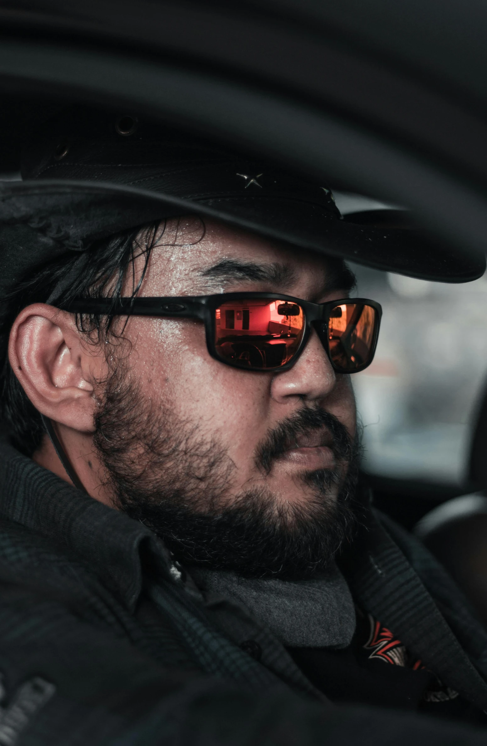 a man wearing sunglasses and a hat in a car