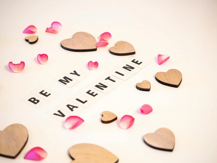 valentine's day greeting with wooden hearts on white background