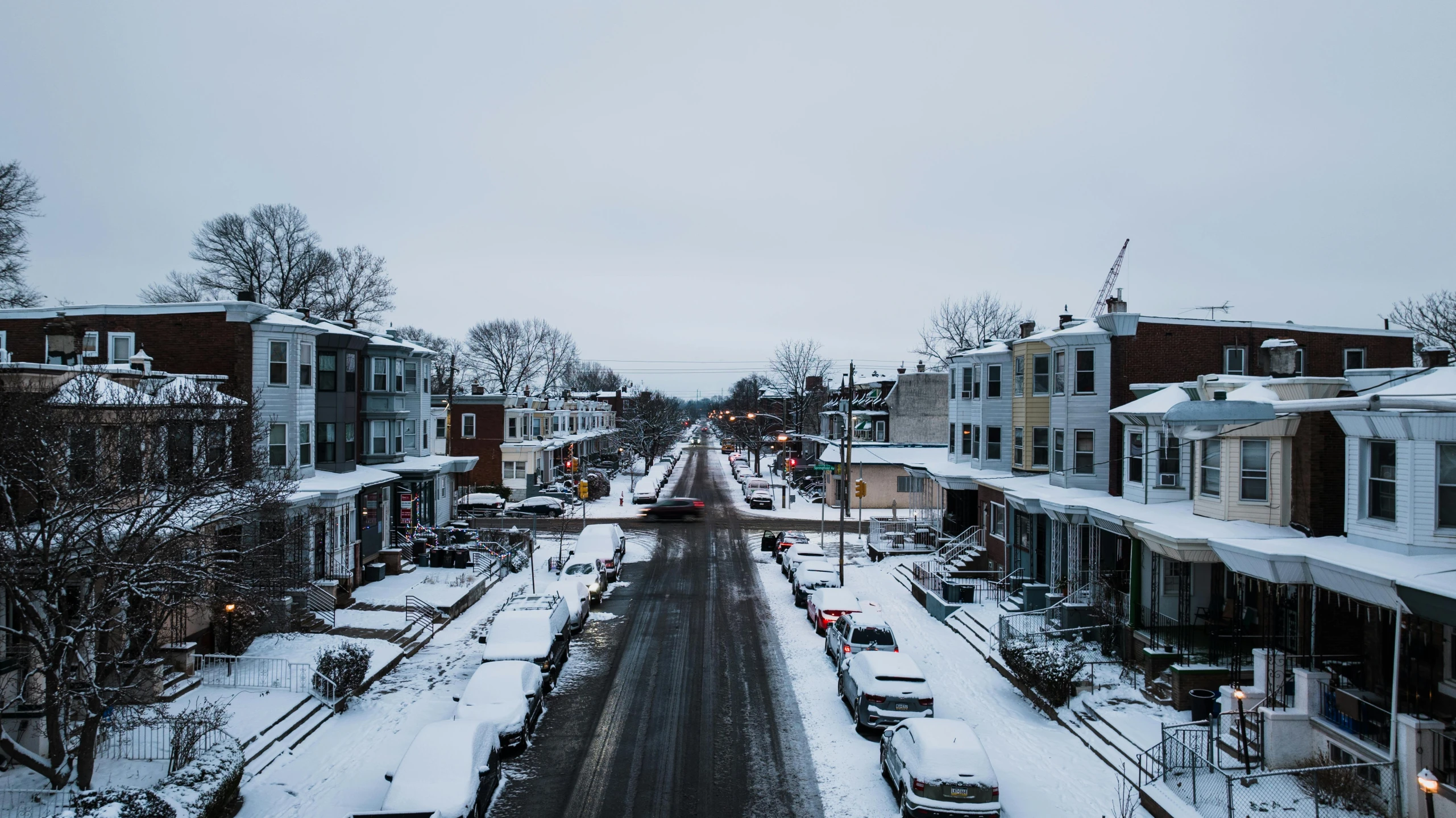 a long road filled with snow covered sidewalks