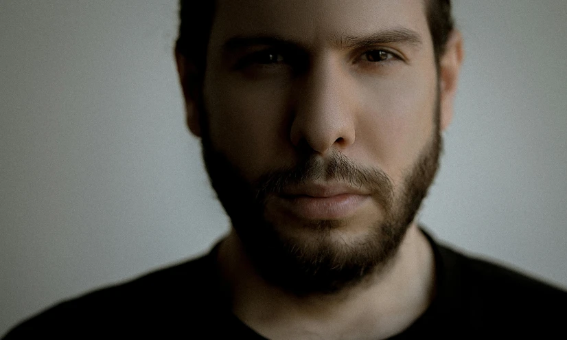 a man with a goatee and black shirt staring at the camera