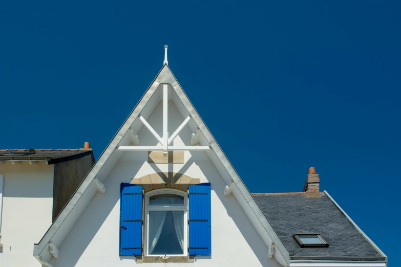 an old house with blue shutters and a steeple