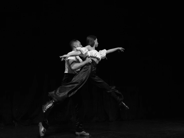 dancers doing an intense act in the dark