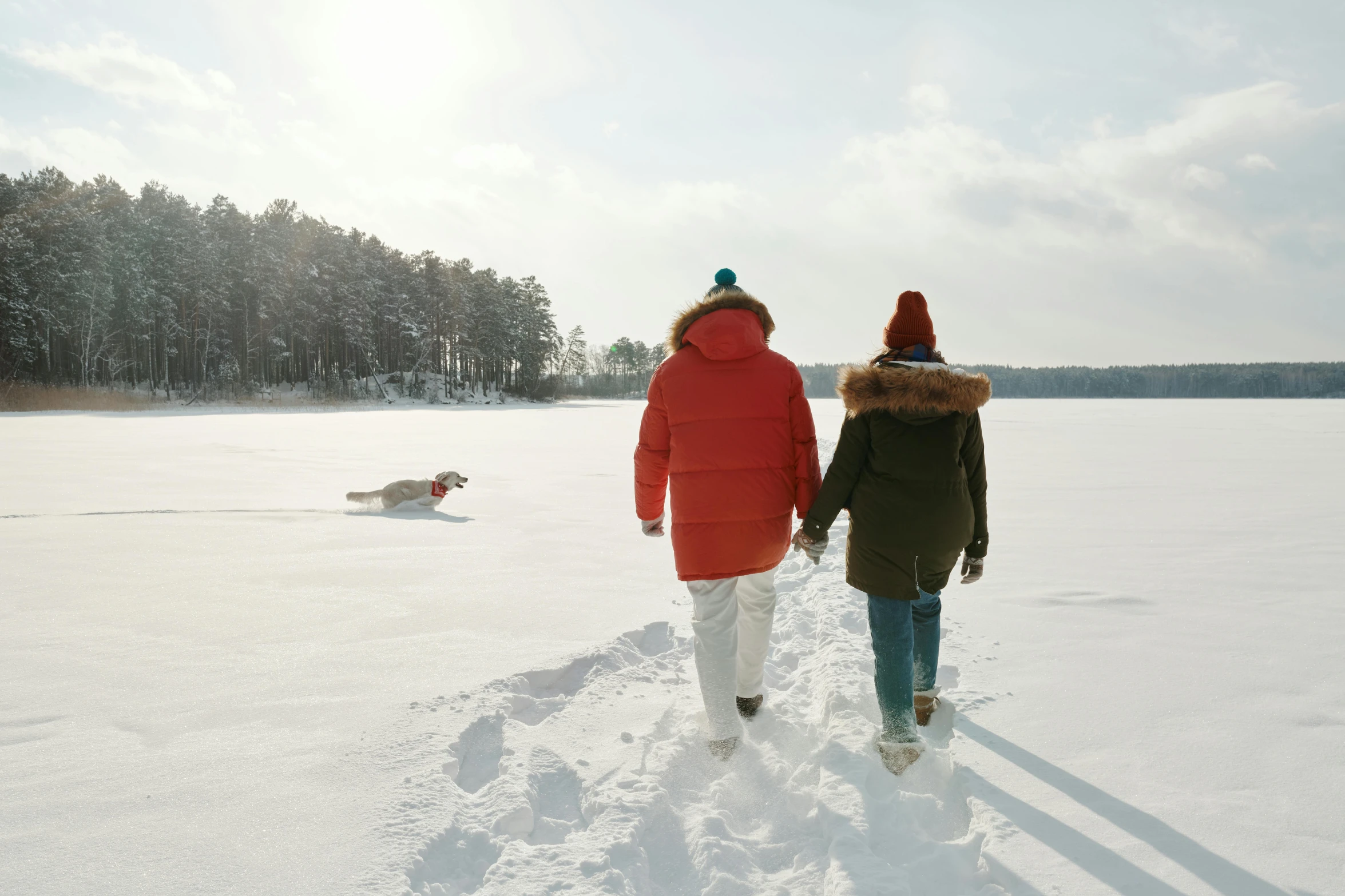 two people walking in the snow holding hands