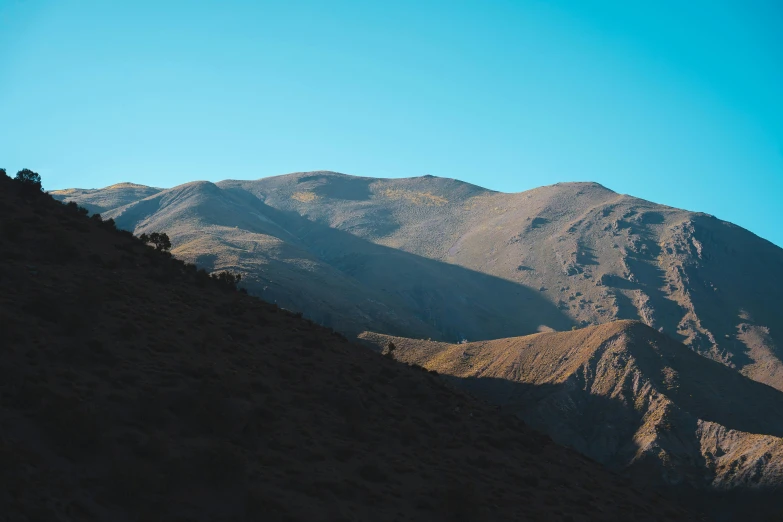 the mountains have a blue sky as they rise high