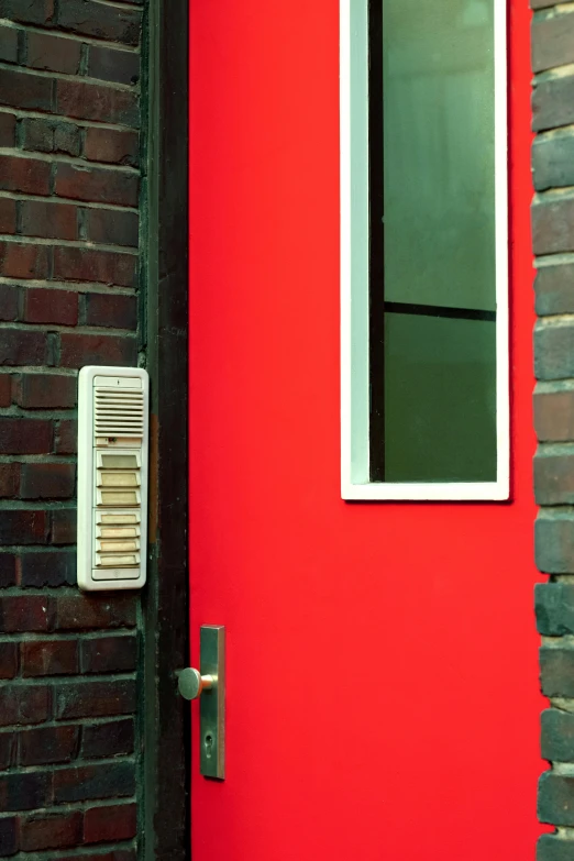 a door is painted red next to a brick building