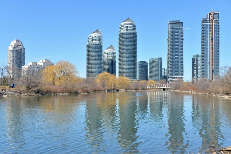 several tall buildings stand next to a lake