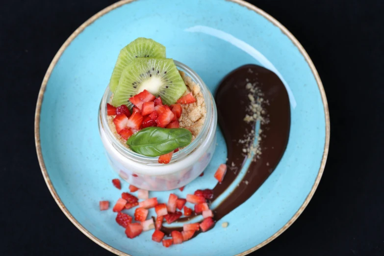 a dessert in a blue bowl on a black background