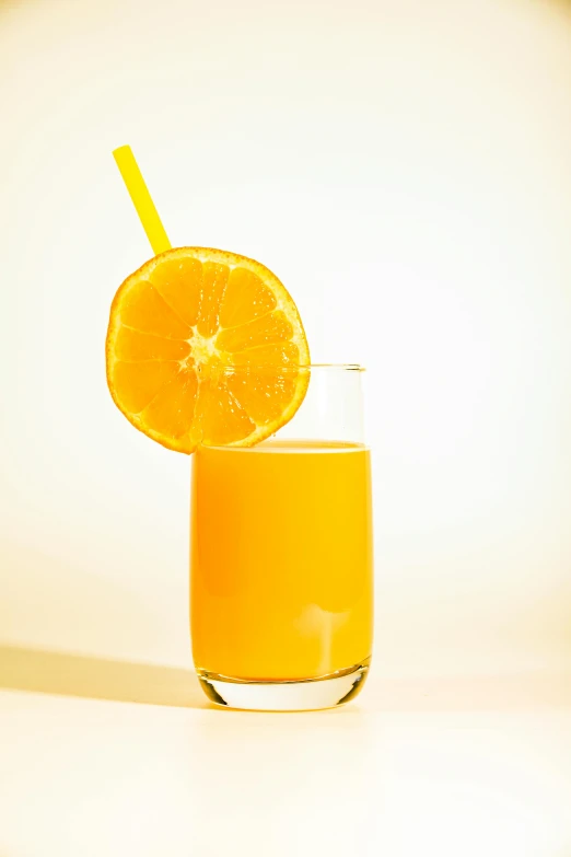 the glass cup is filled with an orange liquid