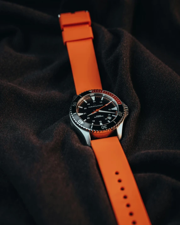 a watch with a red and black band