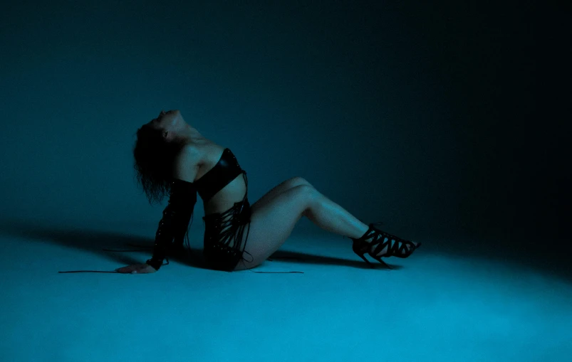 a woman in black and white outfit kneeling on the floor