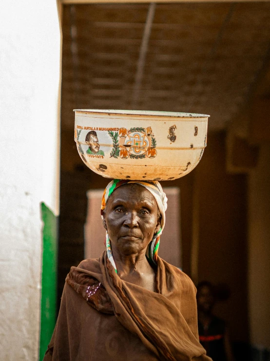 woman carrying a large bowl on her head in india