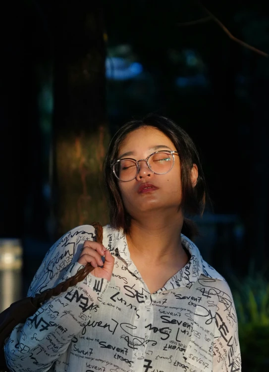 asian woman holding an umbrella while wearing glasses