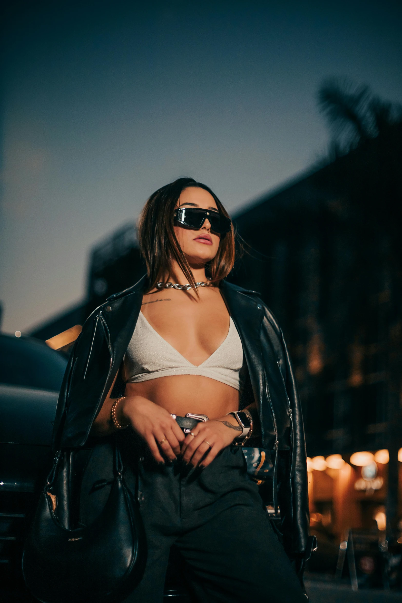 a woman in a bikini top is standing by a car