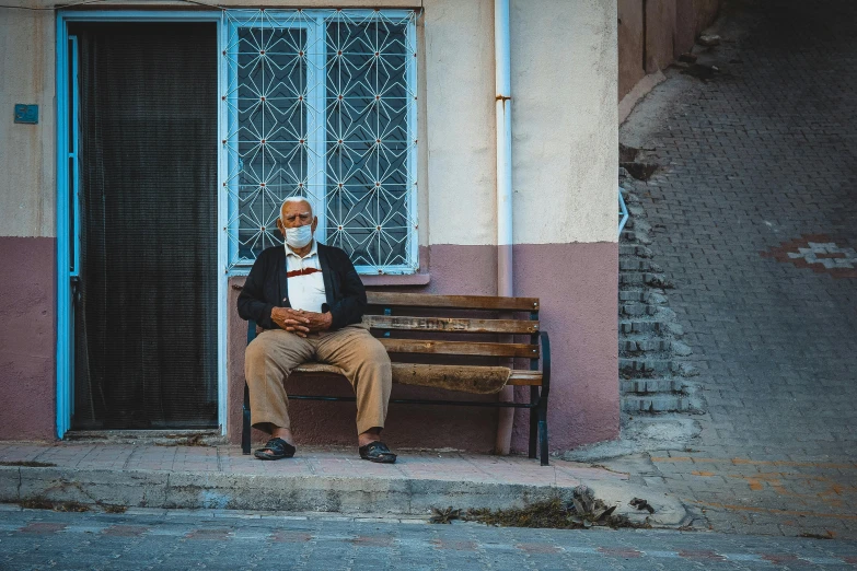 a man is sitting on a bench with an apron