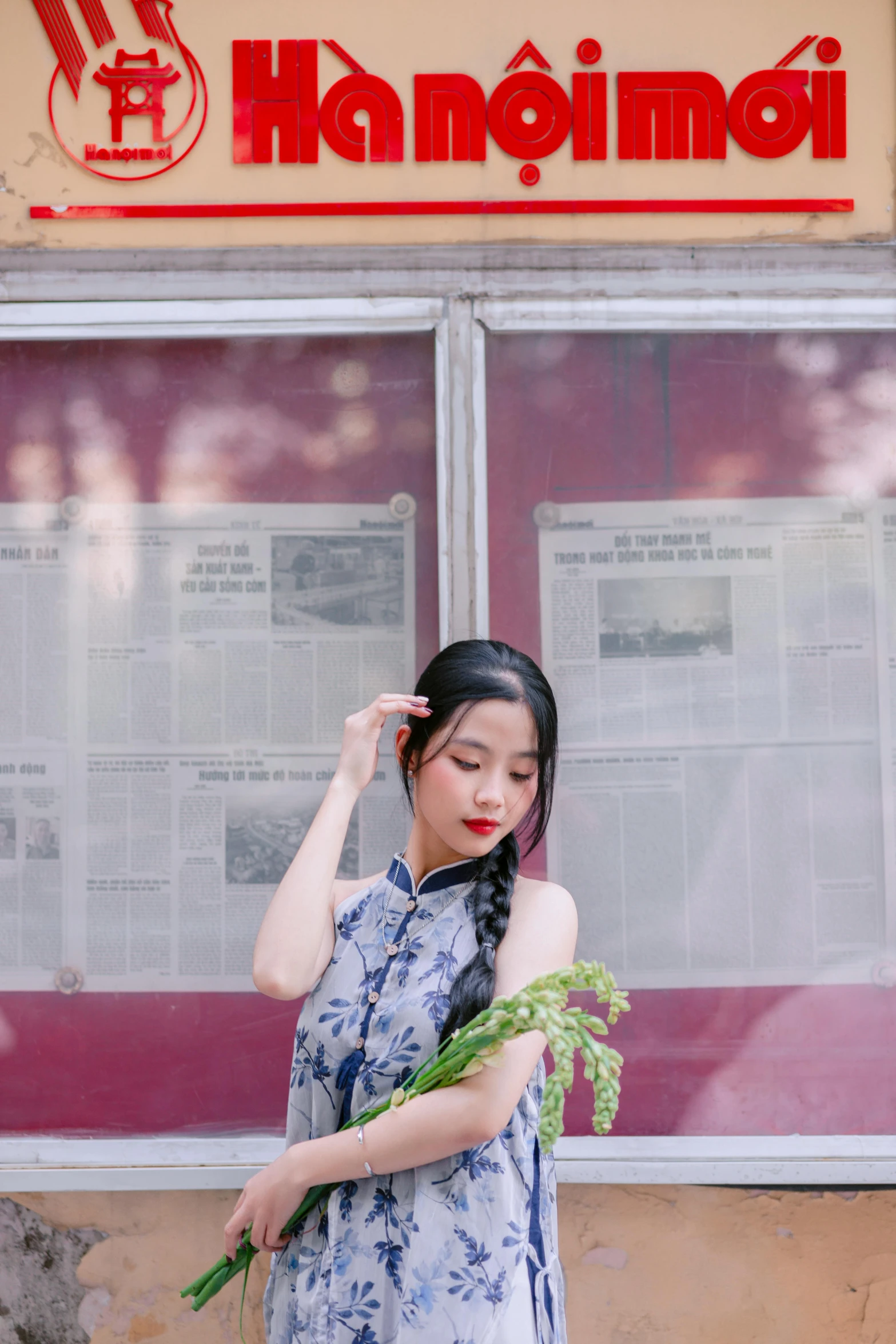 an asian woman holding flowers and standing outside of a nch