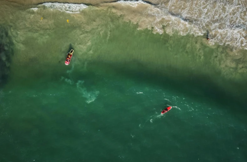 two people are paddling boats in the green water