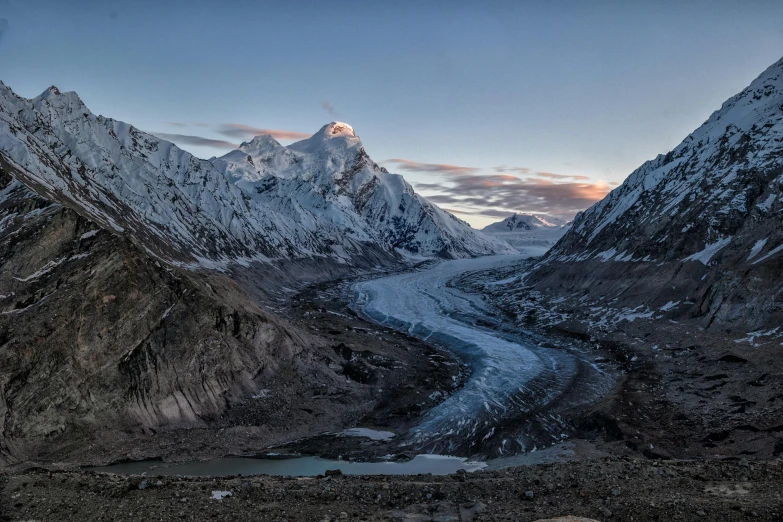 snowy mountains are shown at sunset over a glacier