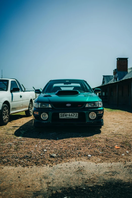 two cars on a field next to buildings