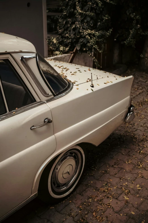 an old car parked on a sidewalk next to another car