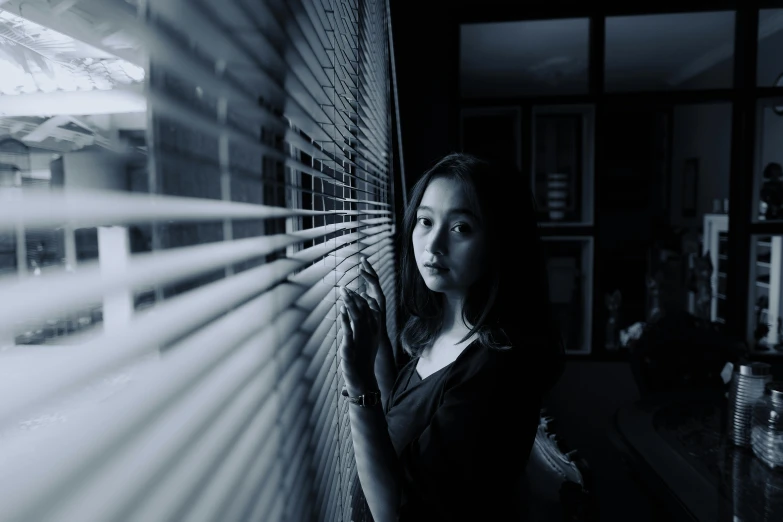 woman standing by the window with light coming through