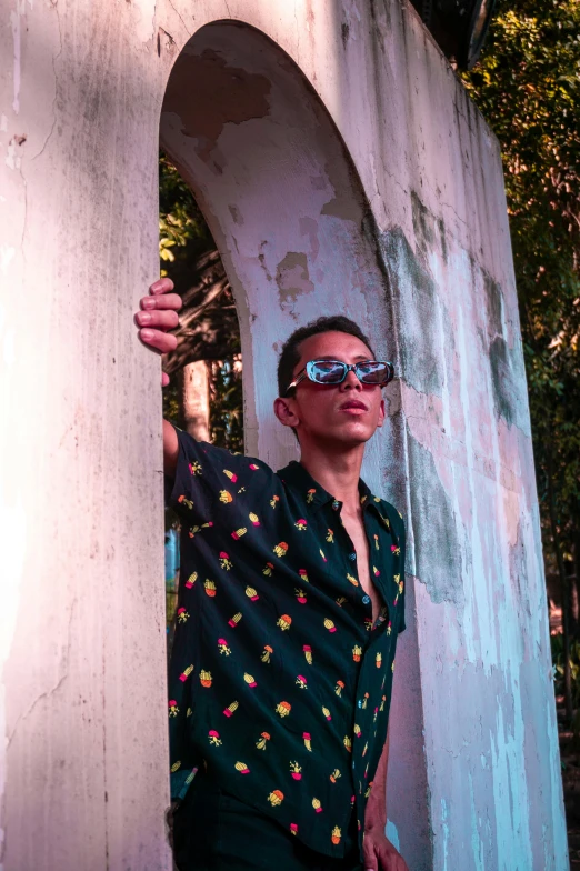 a young man with sunglasses and a green dress shirt