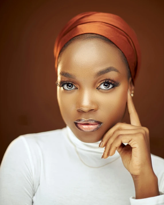 a woman in a white shirt with orange hair wearing an orange head scarf