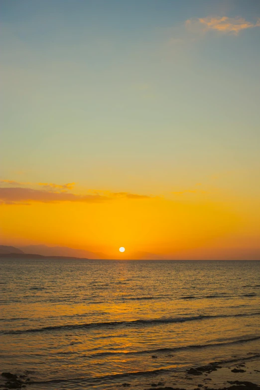 the sun setting over the ocean as it is reflected in the water